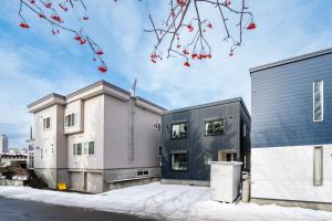 due edifici con bacche rosse su un ramo di un albero di THE GRACIOUS - Vacation STAY 18633 a Sapporo