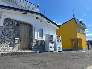 a yellow and white building with a door at Minpaku Dorihu - Vacation STAY 18675 in Taiki