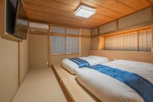 two beds in a room with two windows at Miyabi Sengokuhara Hot Spring Villa - Vacation STAY 60344v in Sengokuhara