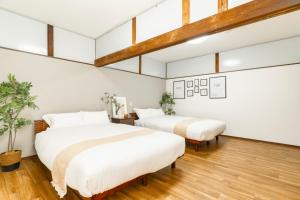 two beds in a room with white walls and wood floors at Asahi - House - Vacation STAY 18691 in Asahi +55 photos