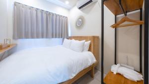 a small bedroom with a white bed and a window at Canggu Irab - Vacation STAY 66913v in Sarahama +13 photos