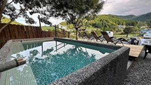 a swimming pool with chairs sitting next to a fence at NATURE HEALING KAMIYAMA - Vacation STAY 71981v in Yorii