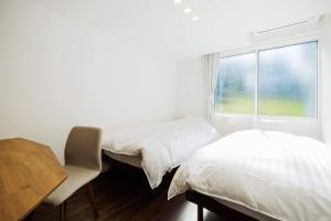 a bedroom with two beds and a desk and a window at Villa Zao - Vacation STAY 73045v in To-katta