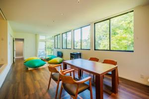 a dining room with a table and chairs and windows at Villa Zao - Vacation STAY 73045v in To-katta