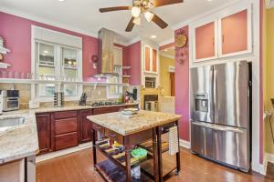 a kitchen with pink walls and a stainless steel refrigerator at Charming Victorian Home with Porch & Large Yard home in Catonsville