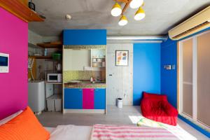 ein Zimmer mit blauen und rosa Wänden und eine Küche in der Unterkunft Stayloopスカイツリー in Tokio