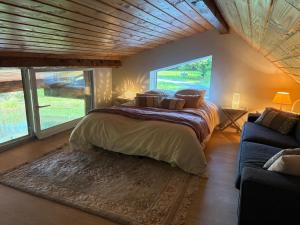 a bedroom with a large bed and a couch at La cabane sur l'étang in Étival-Clairefontaine