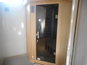a wooden cabinet with a glass door in a room at Youth Hostel KiKai - Vacation STAY 92589v in Akaren