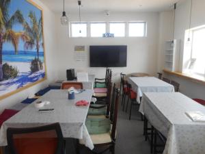 a dining room with two tables and a flat screen tv at Youth Hostel KiKai - Vacation STAY 92589v in Akaren