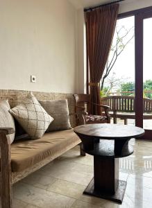 una sala de estar con un sofá y una mesa en Villa Lotus 8, en Canggu