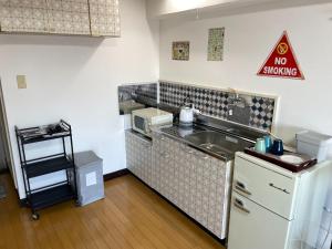a small kitchen with a sink and a no smoking sign at YS Minami Miyazaki No, 901 - Vacation STAY 18876 in Miyazaki