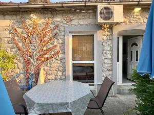 a table and chairs in front of a stone house at Stevova gajba in Meljine