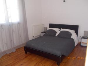 1 cama en un dormitorio con suelo de madera en Gite Louis, en Saint-Paul-des-Fonts