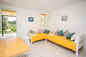 two yellow beds in a room with a table at Pelagos in Stafylos