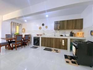a kitchen and dining room with a table and a stove at kisimani Nest in Mombasa
