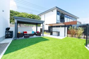 a backyard with a green lawn in front of a house at Bridge View Villa - Vacation STAY 80945v in Awaji