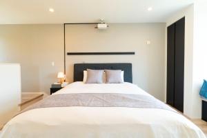 a bedroom with a large white bed with a black headboard at Bridge View Villa - Vacation STAY 80945v in Awaji