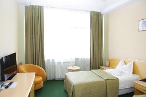 
a hotel room with two beds and a television at Eurohotel in Baia Mare
