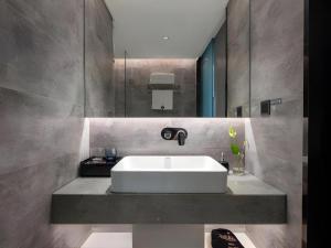 a bathroom with a white sink and a mirror at Aishang Hotel (Lecong Furniture Mall, Foshan) in Shunde +195 photos