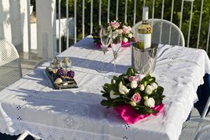 a white table with flowers and wine glasses on it at Case Della Baia in Castellammare del Golfo