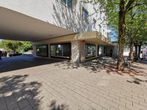 un edificio con un árbol delante en BodenSEE Friedrichshafen City Apartment "LARA", en Friedrichshafen