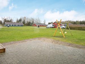 a playground with a swing and balls in a field at 4 star holiday home in Nordborg in Nordborg