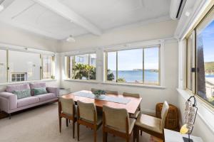 a dining room with a table and chairs at Fairlight 2-Bed Apartment Steps from the Beach in Sydney +6 photos