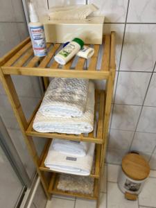 a wooden shelf with towels and other items in a bathroom at Olymp Hotel in Magdeburg +10 photos