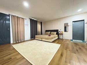 a large room with a bed and a large rug at Homestay Kenangan Kati Kuala Kangsar in Kuala Kangsar
