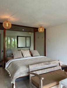 Un dormitorio con una cama grande y una silla. en Villa Lotus 8, en Canggu
