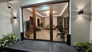 eine offene Glastür zu einem Wohnzimmer mit Pflanzen in der Unterkunft Willa Zacisze Szczawnica 25 m2 in Szczawnica