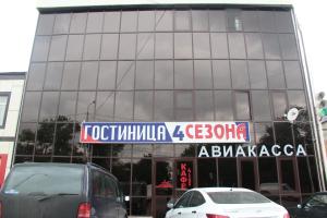 een glazen gebouw met een bord ervoor bij Gostinitsa Chetyre Sezona in Groznyy