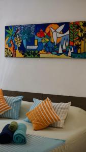 a bed with pillows and a painting on the wall at Gardens Retreat, Peaceful Bungalow near Beach in Pereybere