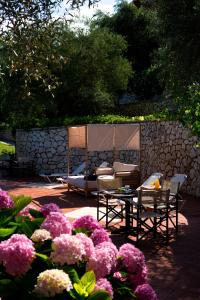 a garden with chairs and a table and flowers at Evridiki's Villas in Agios Nikitas