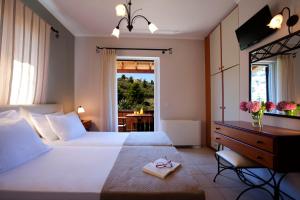a bedroom with a bed and a desk and a window at Evridiki's Villas in Agios Nikitas