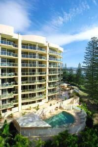 a large building with a swimming pool in front of it at Northpoint Apartments in Port Macquarie
