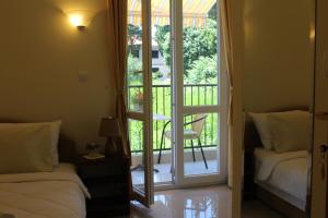 a bedroom with a door open to a balcony with a chair at Swiss Residence Montenegro in Herceg-Novi