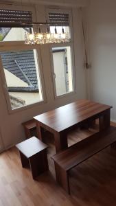 a dining room with a wooden table and two windows at Boardinghaus Niederrhein in Viersen