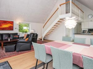 a dining room and living room with a table and chairs at 6 person holiday home in Rømø-By Traum in Toftum