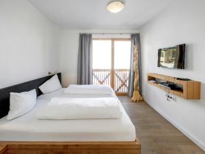 a bedroom with two beds and a tv on a wall at Apartment in Gerlos near Ski Slopes in Gerlos +14 photos