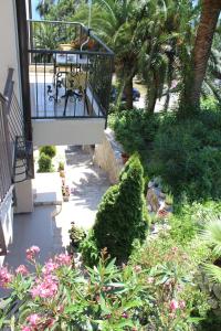 a balcony with a table in a garden with plants at Swiss Residence Montenegro in Herceg-Novi