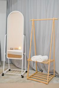 a mirror and a chair next to a towel rack at Singah in Bukit Mertajam