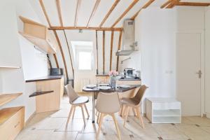 eine Küche mit Esstisch und Stühlen in der Unterkunft Center of Paris Luxurious Studio Apartment Free NetFlix in Paris