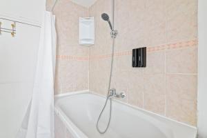 Das Bad ist mit einer Dusche und einer Badewanne ausgestattet. in der Unterkunft Center of Paris Luxurious Studio Apartment Free NetFlix in Paris