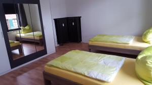 フィーアゼンにあるBoardinghaus Niederrheinの小さな部屋で、ベッド2台、鏡が備わります。