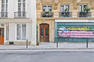ein Gebäude mit einer Tür mit Graffiti drauf in der Unterkunft Center of Paris Luxurious Studio Apartment Free NetFlix in Paris