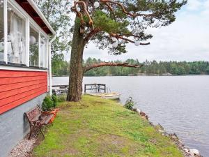 オーケシュバーリアにある5 person holiday home in ÅKERSBERGAの木と船の横にベンチのある家 +17枚の写真