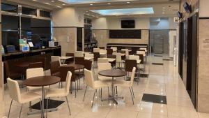 a restaurant with tables and chairs and a bar at Toyoko Inn Nagareyama-Otakanomori Ekimae in Nagareyama