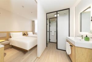 a hotel room with a bed and a bathroom at Hi Inn Beijing Olympic Park in Beijing