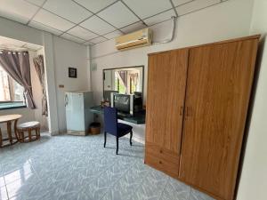 a living room with a large wooden cabinet and a television at Karon Cove at Seabreeze Inn in Karon Beach